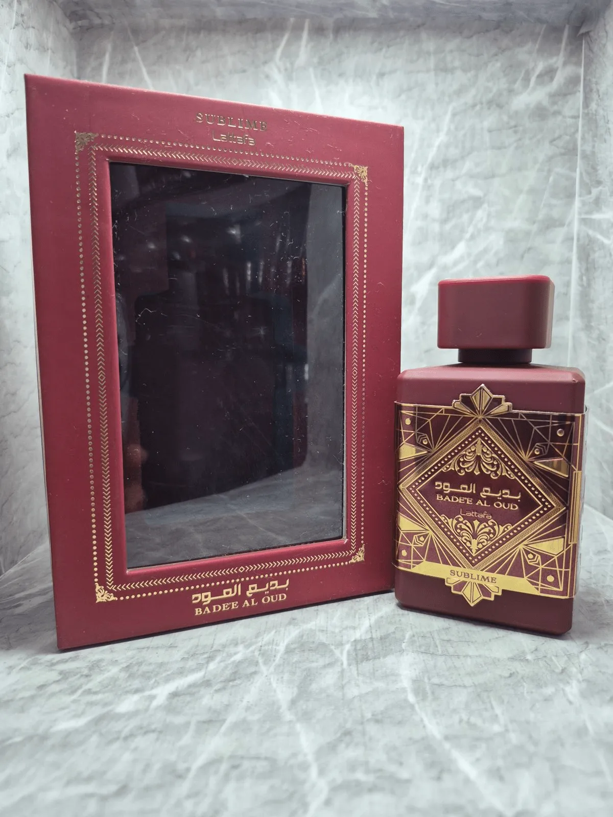 Perfume árabe Lattafa Bade'e Al Oud Sublime en frasco rojo mate con grabados dorados y caja original.