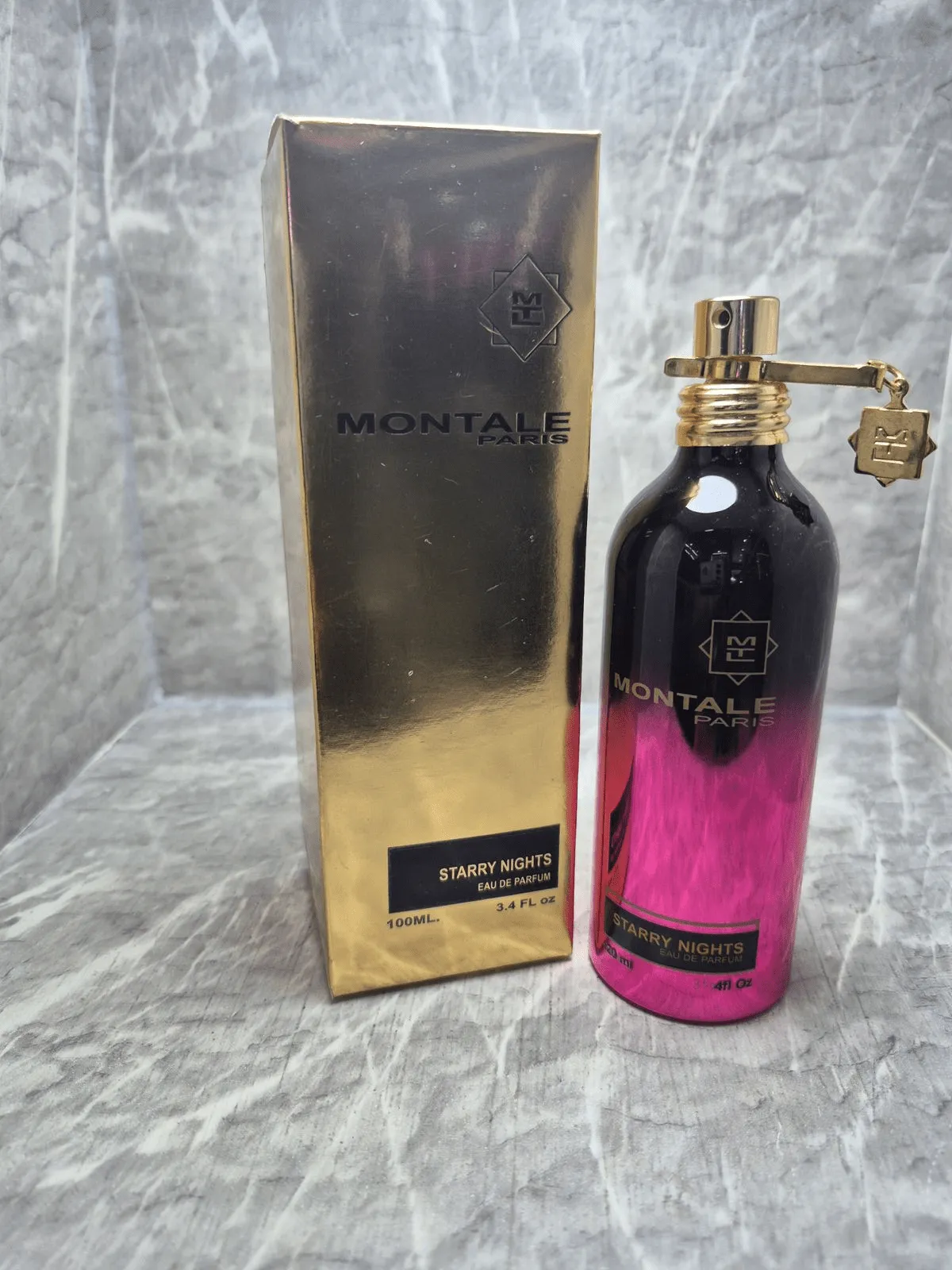 Perfume original Montale Starry Nights en envase de aluminio con degradado negro a fucsia y caja dorada original.