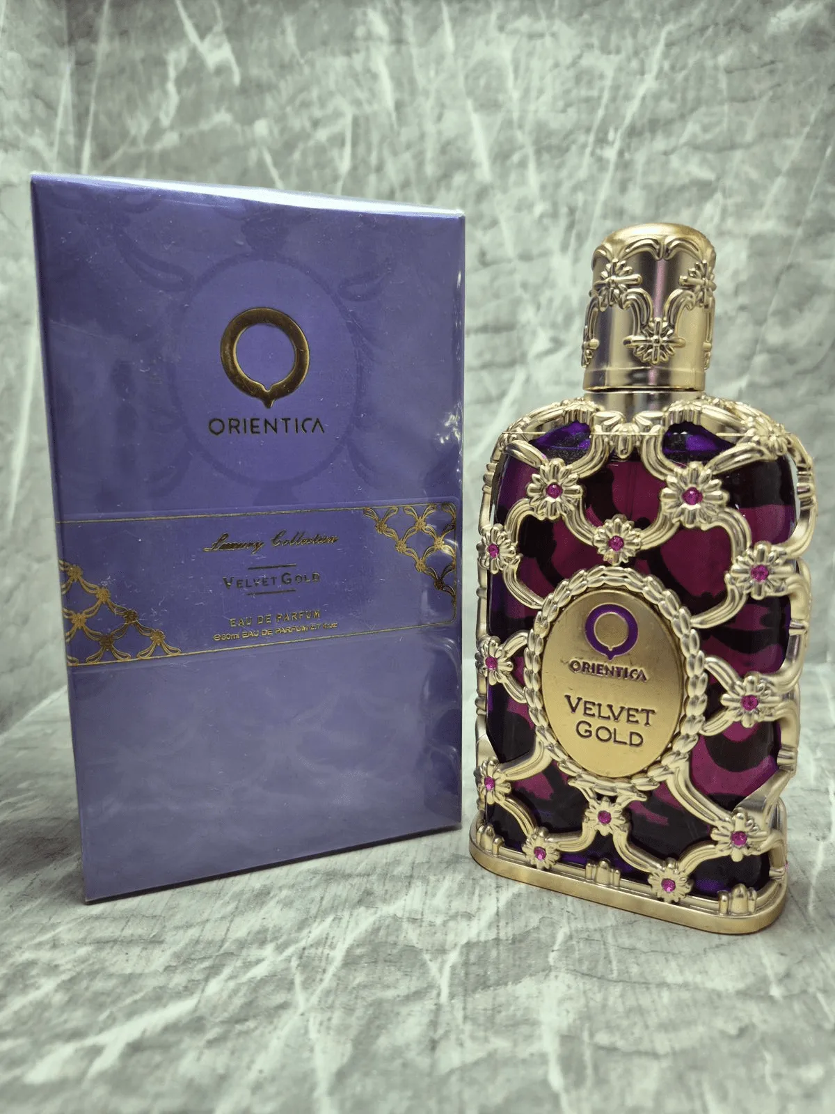 Perfume árabe Orientica Velvet Gold para mujer en frasco morado con diseño de malla dorada y caja original.