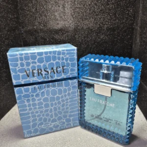 Perfume original Versace Man Eau Fraiche para hombre en frasco azul claro con bordes dentados y caja original.