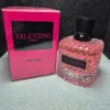 Perfume Valentino Donna Born in Roma para mujer en frasco rosado con tachuelas y caja rosa fucsia.
