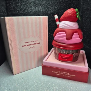Perfume árabe Berry On Top Lattafa en frasco con forma de postre de fresa y caja rosada.