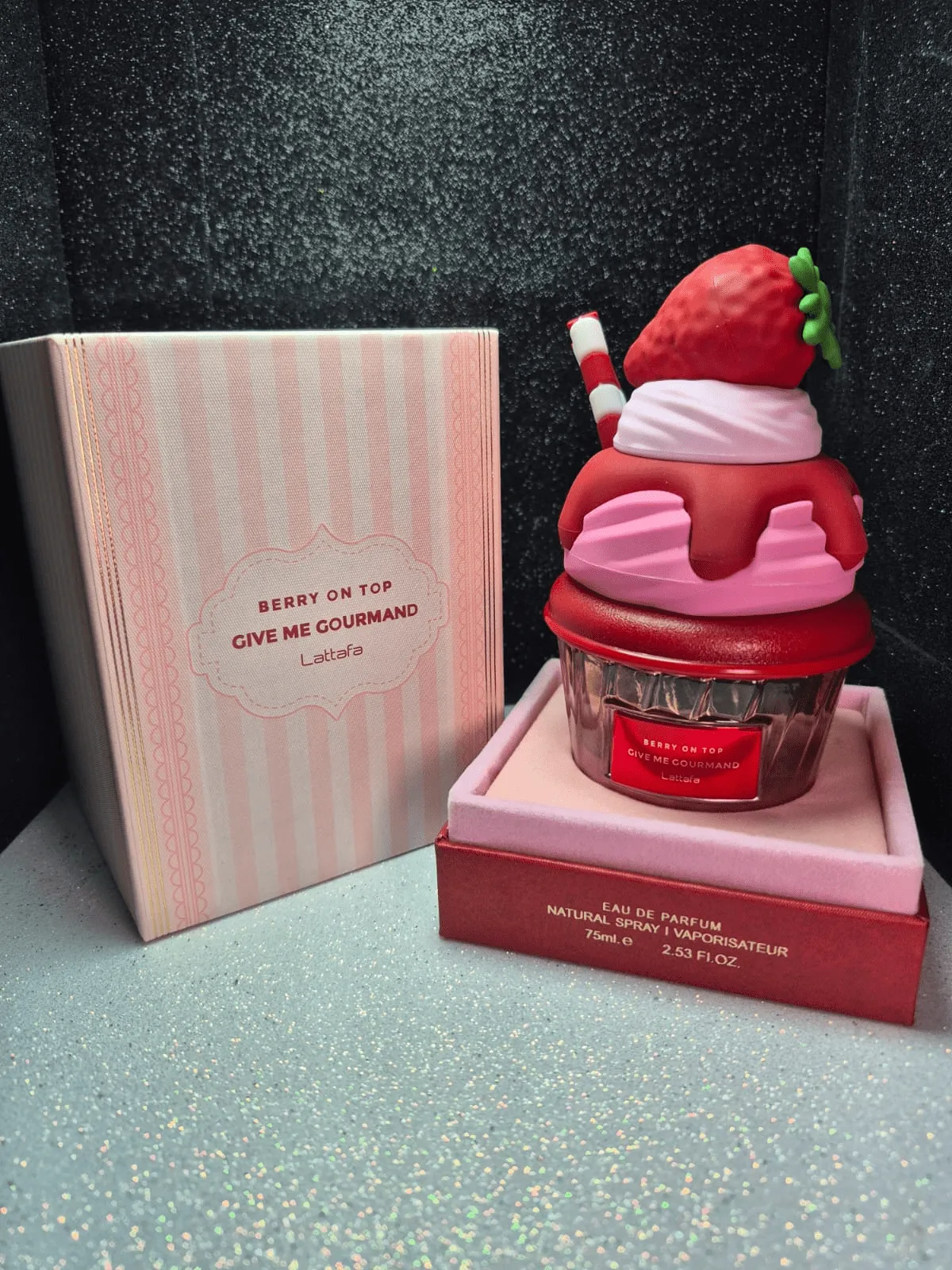 Perfume árabe Berry On Top Lattafa en frasco con forma de postre de fresa y caja rosada.